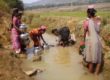 Indian women getting water from dirty river