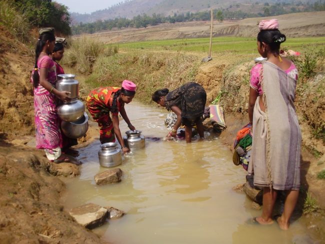 Indian women getting water from dirty river
