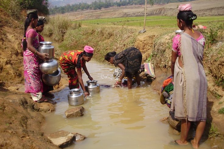 Indian women getting water from dirty river Indian women getting water from dirty river