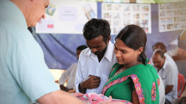 Jim dedicating baby during a vision trip.
